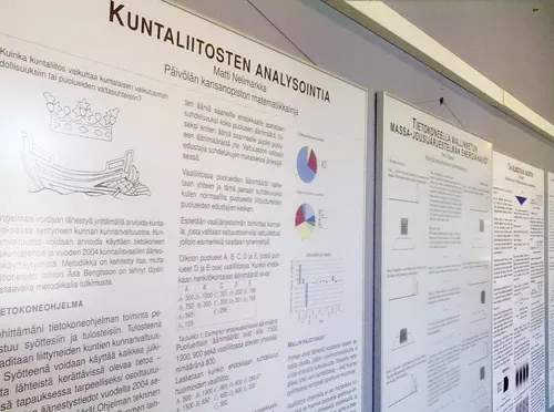 Kilpailumenestystä saavuttaneiden tutkielmien julisteet koristavat matematiikkalinjan rakennuksen seiniä.
